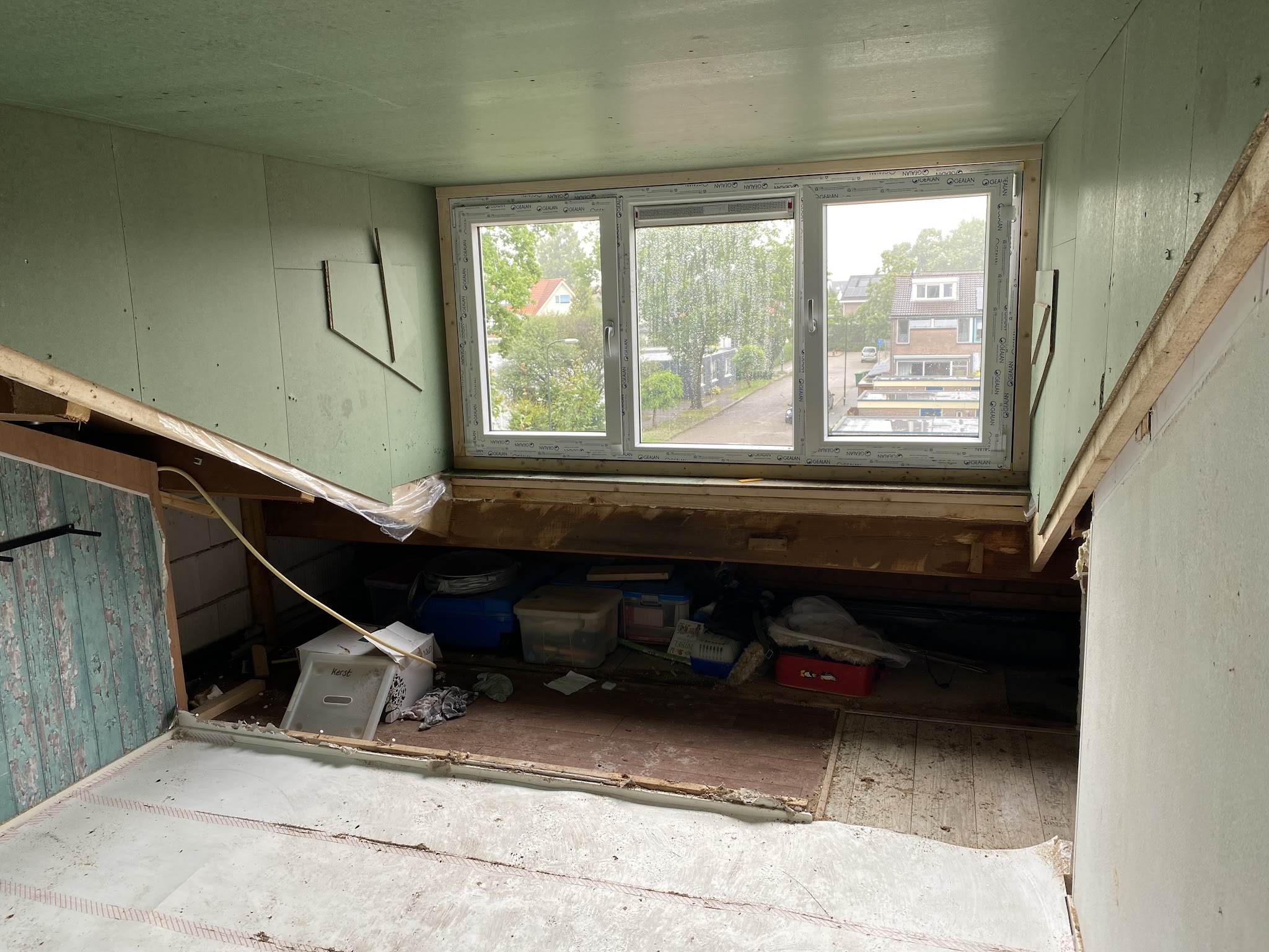 Nieuwe dakkapel van binnen tijdens de afbouw, met breed kozijn en uitzicht op de straat